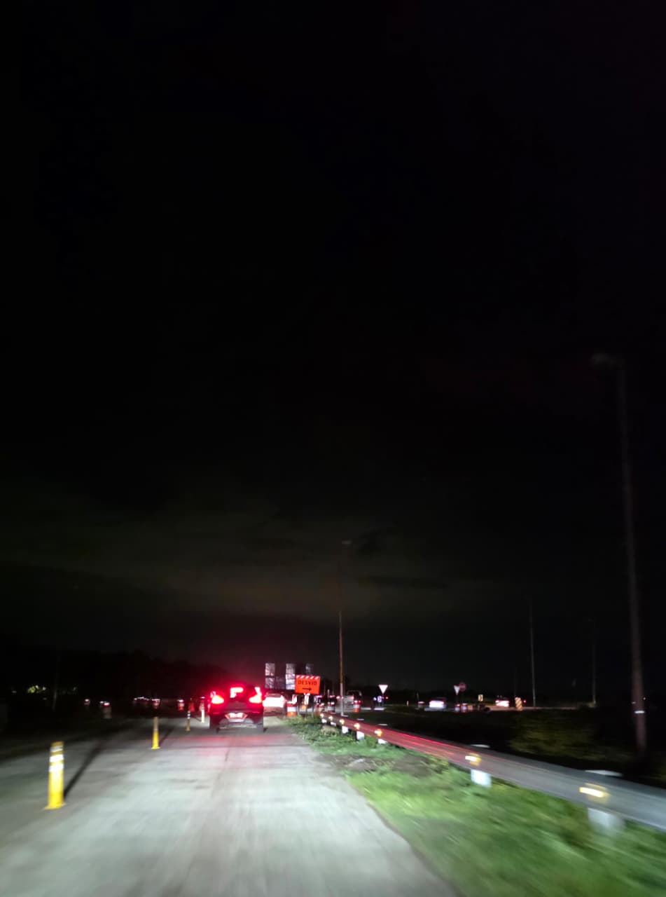 Acceso a la rotonda de Los Bosquecitos sin luz, con conos y señalización de obra, el domingo a la noche